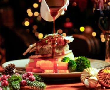 Festive dinner with turkey and vegetables, rich gravy, and elegant decor at luxurious hotel restaurant.