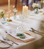 Elegant table setting with fine china, crystal glasses, and candles, offering a sophisticated dining experience.
