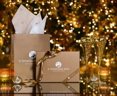 Elegant hotel lounge with festive decor, sparkling lights, gift boxes, and crystal glasses, inviting luxury experience.